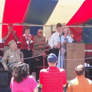 Kathleen Marchese, holding her uncle's medals, begins to thank Senator Kirk and the people of Arlington Heights. Marchese Medals - Arlington Heights 2011